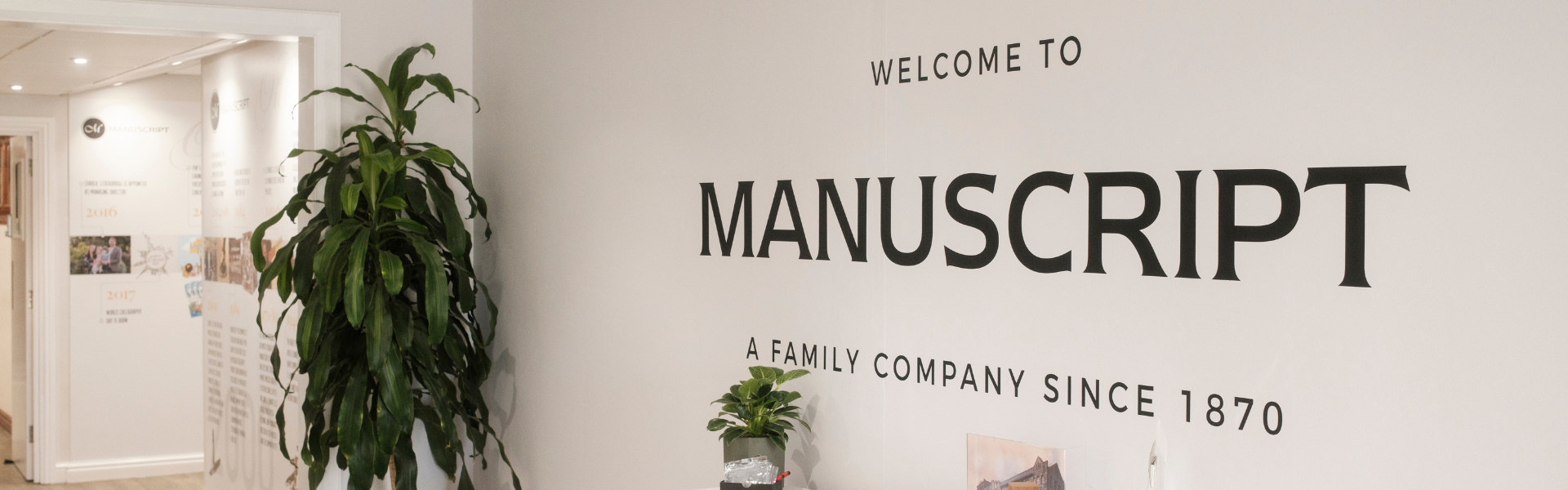 An image of a wall that says welcome to Manuscript, a family company since 1870