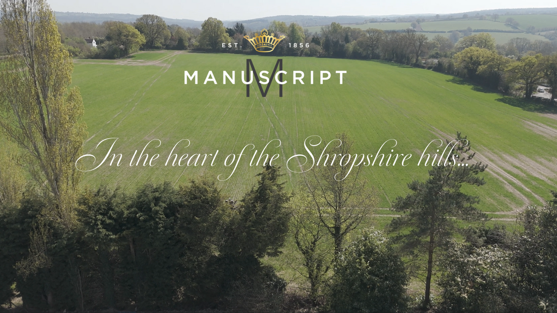 A drone overhead view of the rolling Shropshire hills, which then pans to the Manuscript Pen Co headquarters building. The text reads, in the heart of the Shropshire hills, our legacy continues. 